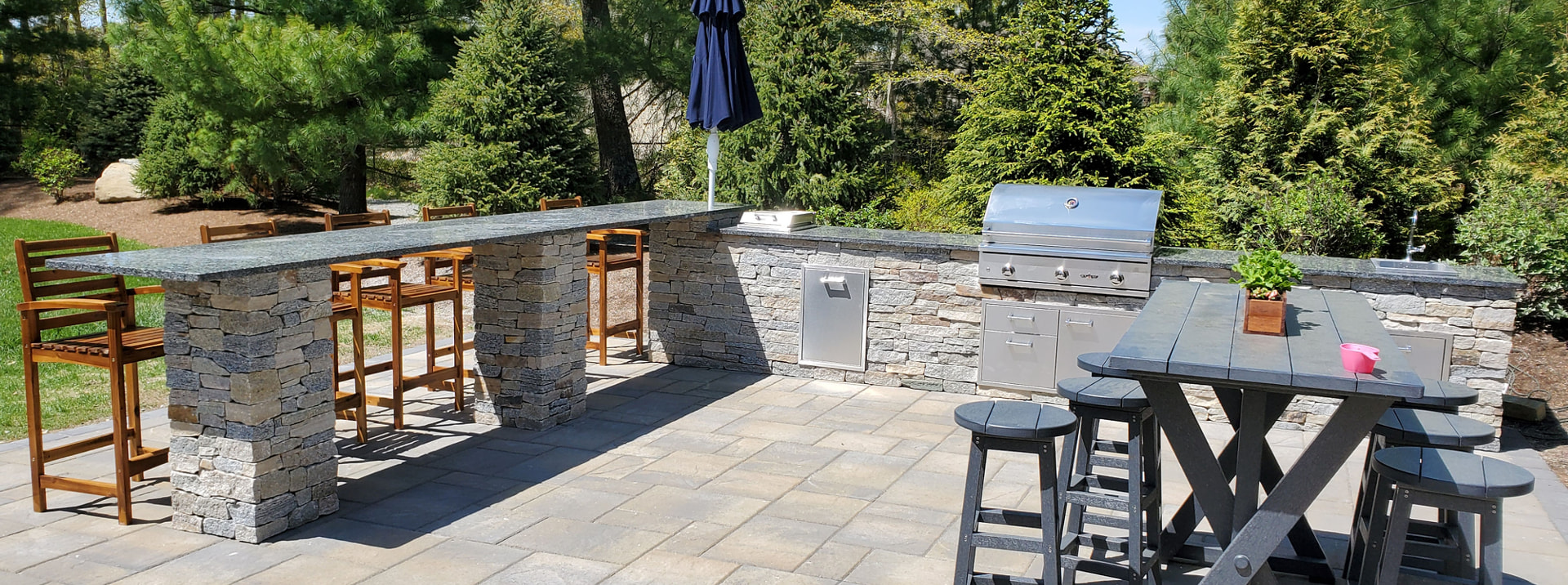 Stone outdoor bar and grill station on a paver patio